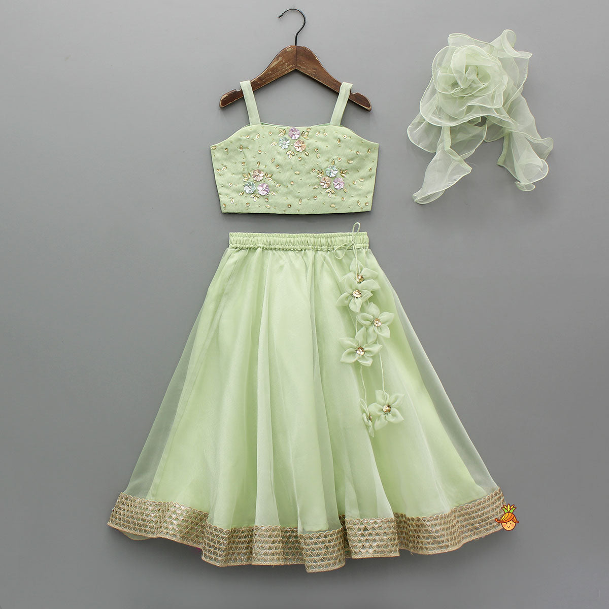 Pre Order: Floral Embroidered Green Sleeveless Top And Fabric Flower Tassels Adorned Lehenga With Ruffle Dupatta