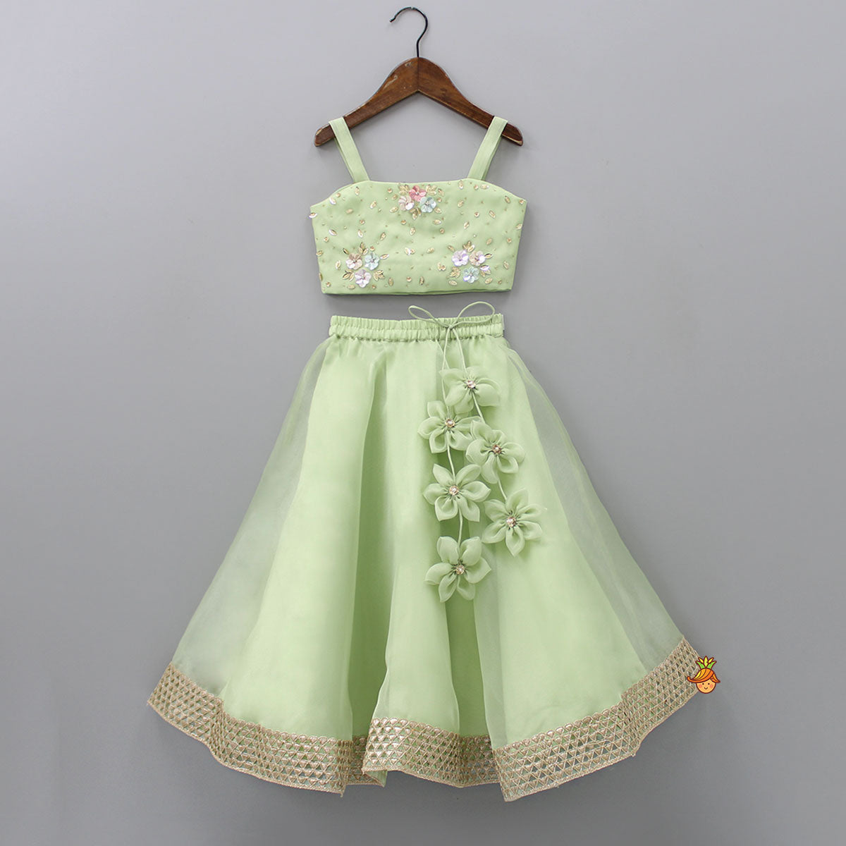 Pre Order: Floral Embroidered Green Sleeveless Top And Fabric Flower Tassels Adorned Lehenga With Ruffle Dupatta