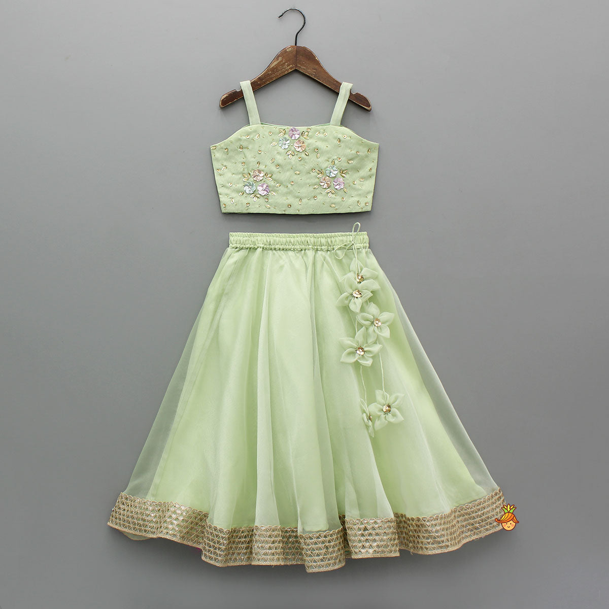 Pre Order: Floral Embroidered Green Sleeveless Top And Fabric Flower Tassels Adorned Lehenga With Ruffle Dupatta