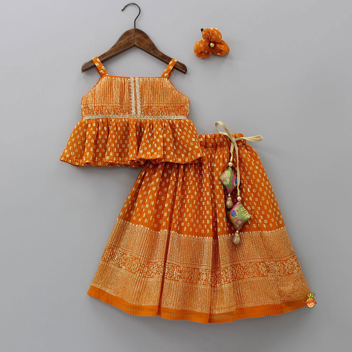 Pre Order: Rust Orange Pleated Georgette Top And Lehenga With Hair Clip