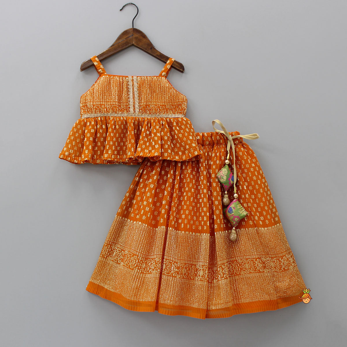 Pre Order: Rust Orange Pleated Georgette Top And Lehenga With Hair Clip