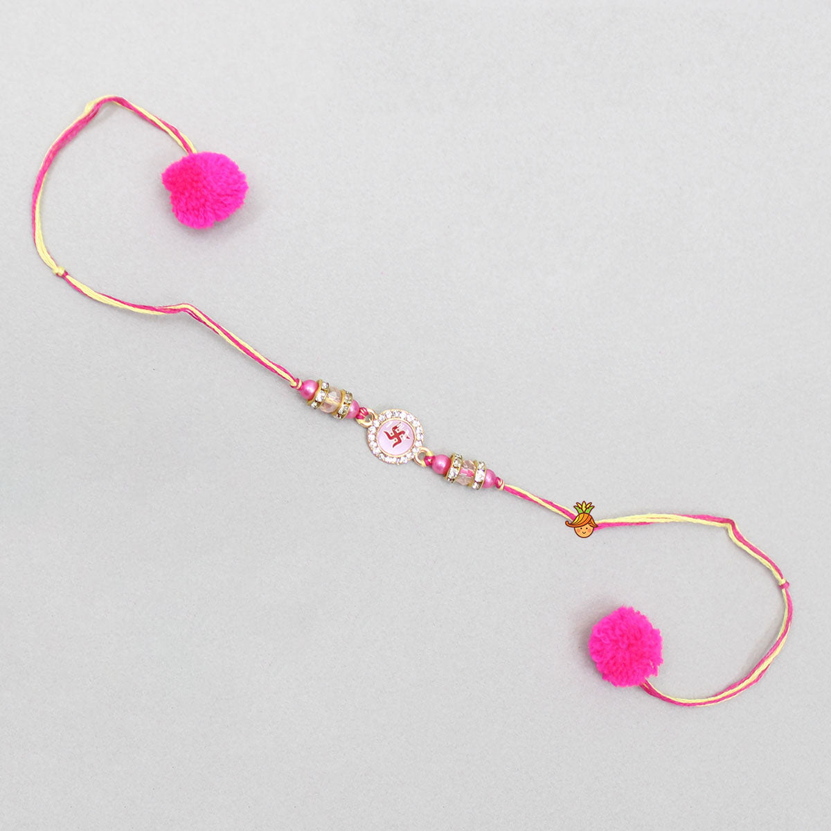 Pink Rakhi Adorned With An Embossed Swastik