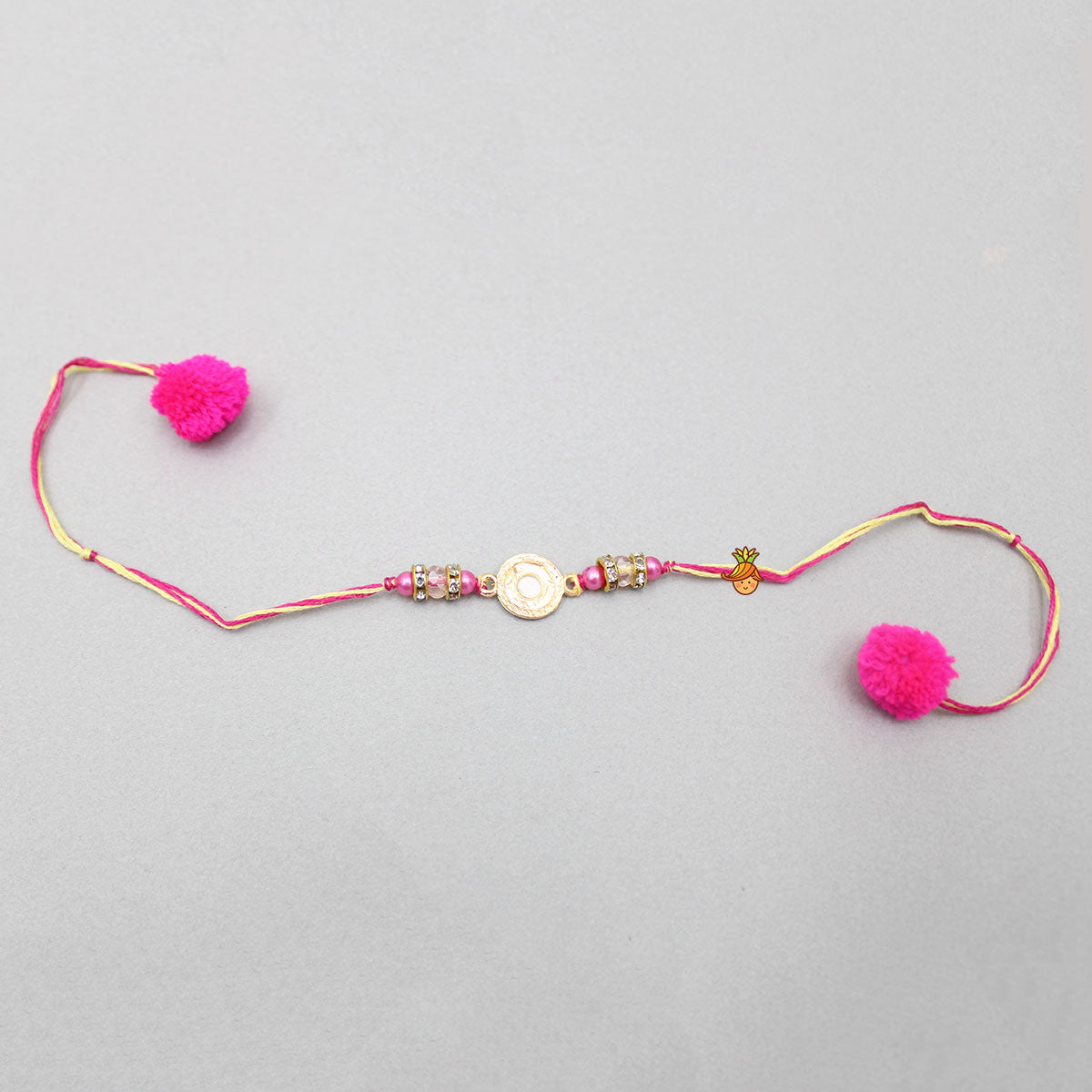 Pink Rakhi Adorned With An Embossed Swastik